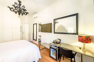 a bedroom with a bed and a desk at Riboty 10 Suites in Rome