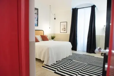 a bedroom with a bed with a black and white rug at Tasso Designer Suite - Colosseum Esquilino in Rome