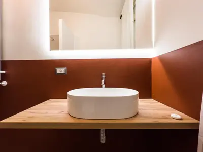 a bathroom with a white sink on a wooden counter at Tasso Designer Suite - Colosseum Esquilino in Rome