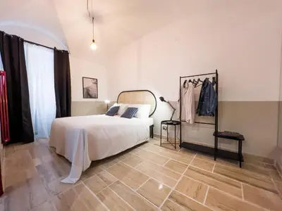 a bedroom with a white bed and a wooden floor at Tasso Designer Suite - Colosseum Esquilino in Rome