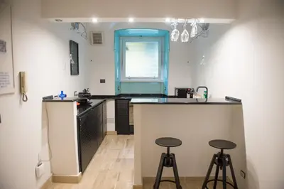 a kitchen with a counter and two stools at Tasso Designer Suite - Colosseum Esquilino in Rome