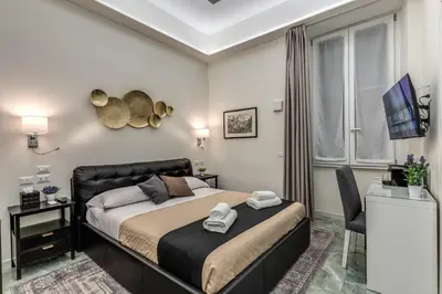 a bedroom with a bed and a chair in it at Adriana 5 Luxury rooms in Rome