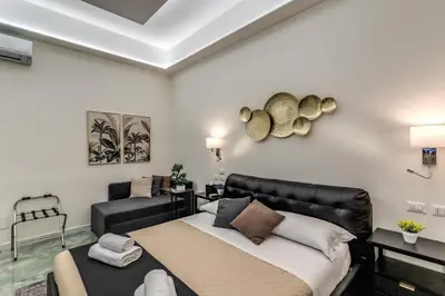 a living room with a bed and a couch at Adriana 5 Luxury rooms in Rome