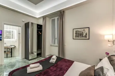 a hotel room with a bed and a bathroom at Adriana 5 Luxury rooms in Rome