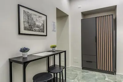 a room with a table and two stools and a door at Adriana 5 Luxury rooms in Rome