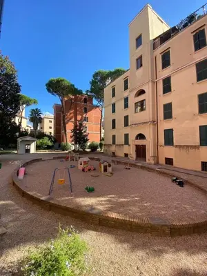 an empty playground in front of a building at Liberty Home in Rome