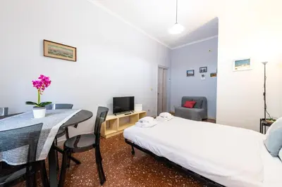 a bedroom with a bed and a table and a tv at Magiù Apartment in Rome