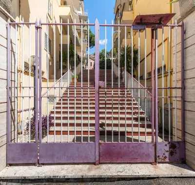 an open gate with stairs in front of buildings at Magiù Apartment in Rome