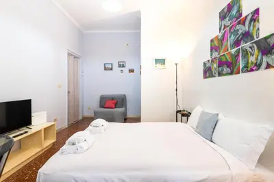 a bedroom with a white bed and a tv at Magiù Apartment in Rome