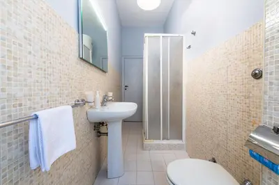 a bathroom with a sink and a toilet and a shower at Magiù Apartment in Rome