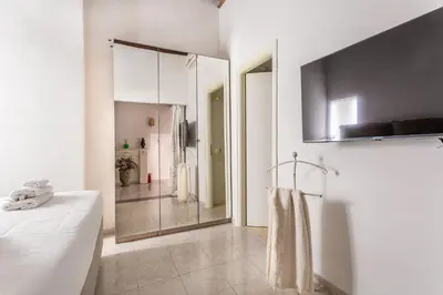 a white bathroom with a large mirror and a bed at iFlat Comfy apt a few steps from the Vatican in Rome