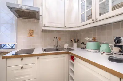 a kitchen with white cabinets and a sink at iFlat Comfy apt a few steps from the Vatican in Rome