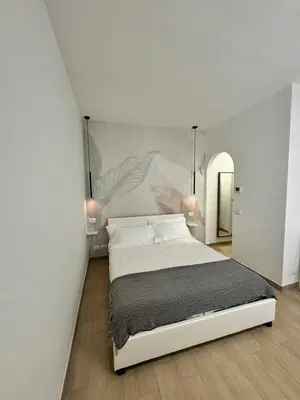 a bedroom with a large bed and a mirror at Little Apartment in Rome