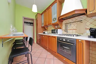 a kitchen with a stove and a table with chairs at Aria di Roma Appartamento in Rome