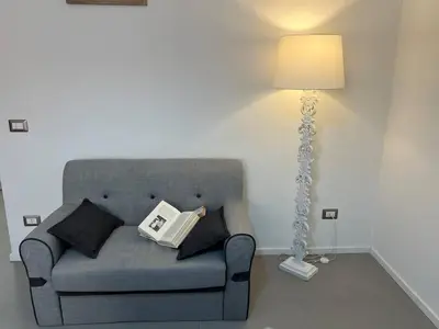 a living room with a gray couch and a lamp at Casa dolce Roma Prati in Rome
