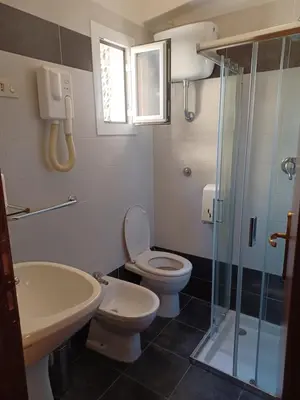 a bathroom with a toilet and a sink and a shower at PITAGORA Rooms in Rome