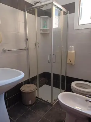 a bathroom with a shower and a toilet and a sink at PITAGORA Rooms in Rome