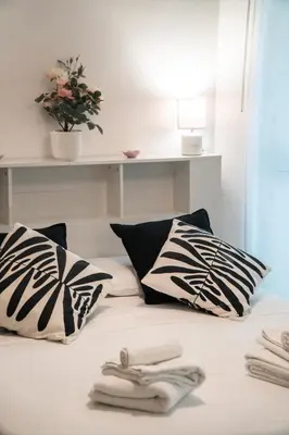 a bed with black and white pillows and a shelf at Candelor House - Apartment & Garden Trastevere in Rome