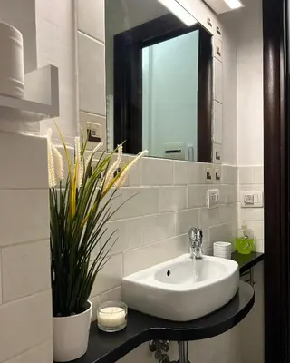 a bathroom with a sink and a mirror at Candelor House - Apartment & Garden Trastevere in Rome