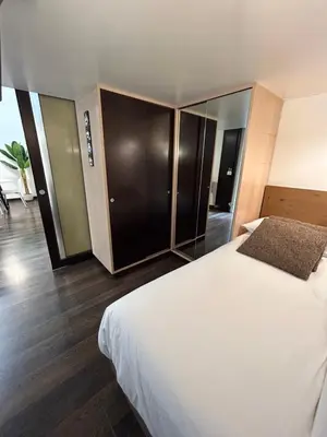a bedroom with a large white bed and wooden floors at Candelor House - Apartment & Garden Trastevere in Rome
