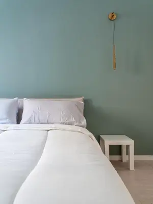 a bed with white sheets and a small table at alPigneto Apartment Rome in Rome