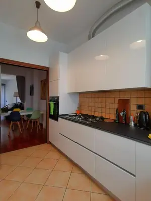 a kitchen with white cabinets and a dining room at Cipro Home in Rome