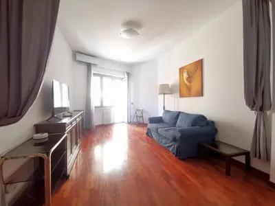 a living room with a blue couch and a wooden floor at Cipro Home in Rome