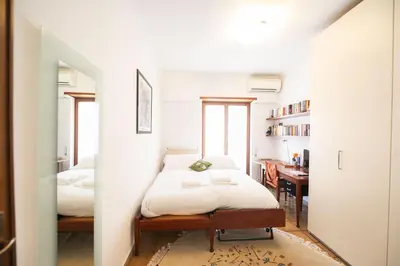 a small bedroom with a bed and a desk at Luminous 2BR Family Apartment in Residential Area in Rome
