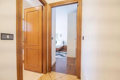 a hallway with a door open to a bedroom at Luminous 2BR Family Apartment in Residential Area in Rome