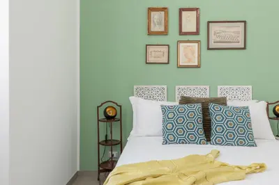 a bedroom with a white bed with pictures on the wall at iFlat Soft & Relaxing apt in Trastevere in Rome