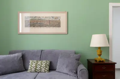 a living room with a gray couch and a lamp at iFlat Soft & Relaxing apt in Trastevere in Rome