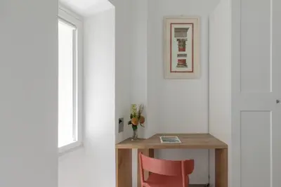 a table with a red chair next to a window at iFlat Soft & Relaxing apt in Trastevere in Rome