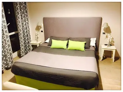 a bedroom with a large bed with two lime green pillows at B&B Exa Rooms - Just Rome in Rome