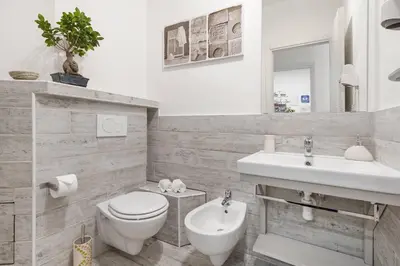 a white bathroom with a toilet and a sink at B&B Exa Rooms - Just Rome in Rome