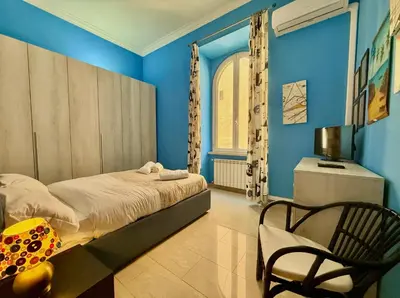 a bedroom with blue walls and a bed and a chair at Casa Flavia in Rome