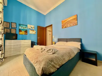 a bedroom with a bed with a blue wall at Casa Flavia in Rome