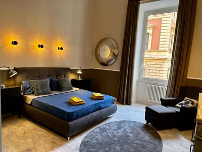 a bedroom with a bed and a chair and a window at The Great Maison in Rome