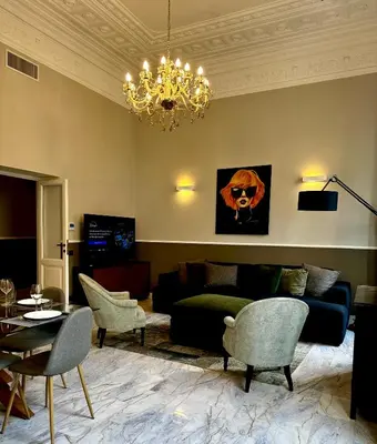 a living room with a couch and a chandelier at The Great Maison in Rome