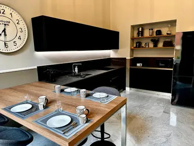 a kitchen with a table and a clock on the wall at The Great Maison in Rome