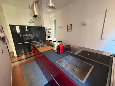 a kitchen with a sink and a red appliance on a counter at Design House Monti in Rome