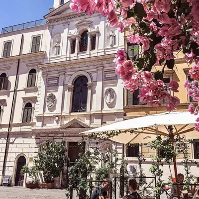 a large building with pink flowers in front of it at Design House Monti in Rome