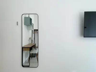 a mirror with a table and a chair in a room at Casa Vittoria in Rome