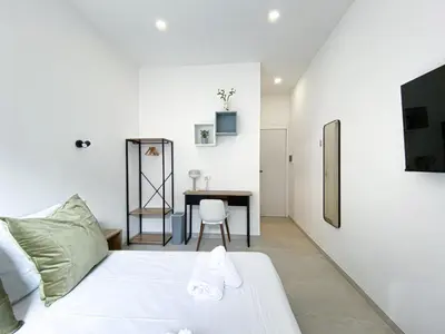 a bedroom with a white bed and a table at Casa Vittoria in Rome