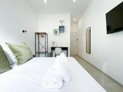 a white bed with a pile of towels on it at Casa Vittoria in Rome
