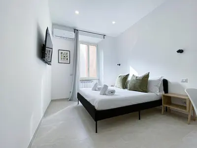 a bedroom with a bed in a white room at Casa Vittoria in Rome