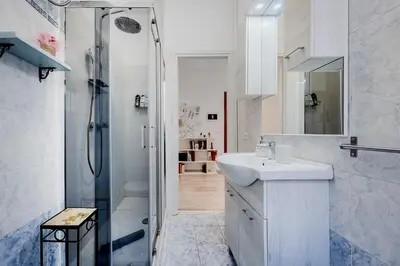 a white bathroom with a sink and a shower at Brandnew luxury house near metro station in Rome