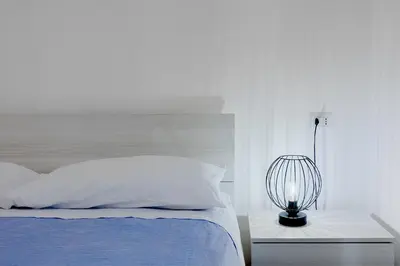 a white bedroom with a bed and a lamp at Brandnew luxury house near metro station in Rome