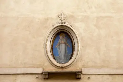a painting of a cross on the side of a building at Views of the Coliseum in Rome