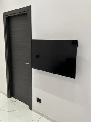 a flat screen tv mounted on a white wall at Heaven of Maya in Rome