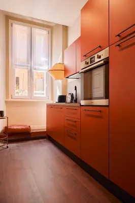 a kitchen with orange cabinets and a window at Maison Luxury Pantheon in Rome